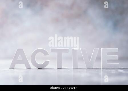 Word ACTIVE made with cement letters on grey marble background. Copy space. Business concept Stock Photo