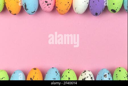 Colorful easter eggs border over a soft pink and pastel background, copy space background and banner cincept for holidays Stock Photo