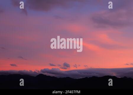 Charming silhouette of mountains and sunset pink sky in dream