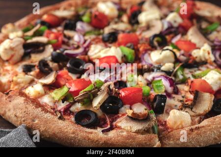 whole fresh round pizza with chicken meat, vegetables, mushrooms and cheese close-up. tasty fast food background in pizzeria side view Stock Photo