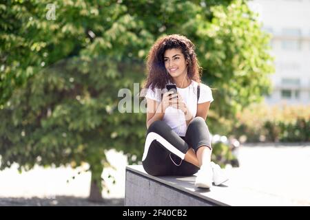 Cheerful young lady in sportswear holding boat pose with cute baby