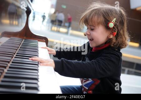 Adorable little girl having fun playing the piano Stock Photo