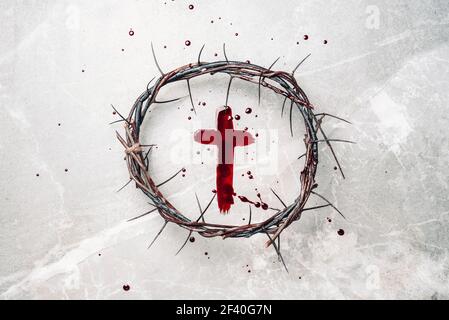 Crucifix made of blood, crown of thorns. Good friday. Easter holiday. Christian cross painted with blood on stone background. Passion, crucifixion of Stock Photo