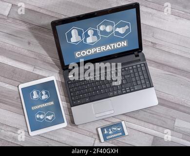 Cooperation concept shown on different information technology devices Stock Photo