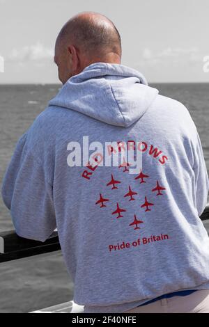 Man wearing Red Arrows Pride of Britain grey hoody at Bournemouth Air Festival, Bournemouth, Dorset UK in August Stock Photo