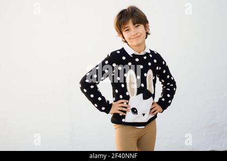 Nice seven years old girl with short hair smiling on camera on a white wall.. Seven years old girl with short hair smiling on a white wall Stock Photo