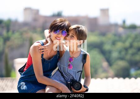Mother and her little daughter traveling together in Granada, Andalusia, Spain with the Alhambra in the background. Mother and her little daughter traveling together in urban background. Stock Photo