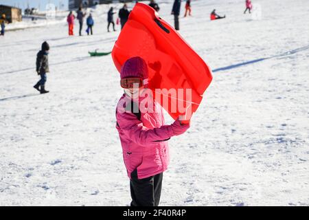 Little girl sledding at Sierra Nevada ski resort wearing snow clothes.. Little girl sledding at Sierra Nevada ski resort. Stock Photo