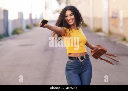 Happy Arab woman wearing casual clothes with open arms in the street.. Happy Arab woman with open arms in the street. Stock Photo