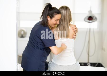 Female Physiotherapist inspecting her patient. Medical check in a physiotherapy center.. Physiotherapist inspecting her patient in a physiotherapy center. Stock Photo