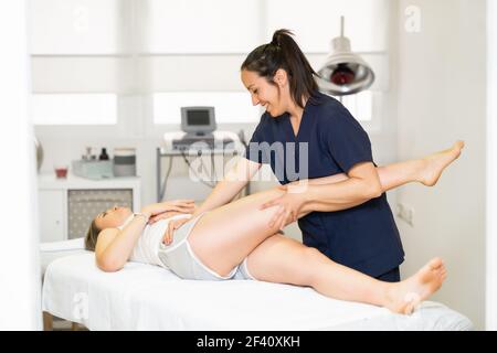 Female Physiotherapist inspecting her patient. Medical check in a physiotherapy center.. Physiotherapist inspecting her patient in a physiotherapy center. Stock Photo
