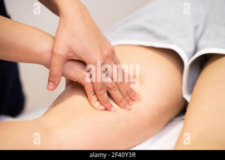 Medical massage at the leg in a physiotherapy center. Female physiotherapist inspecting her patient.. Medical massage at the leg in a physiotherapy center. Stock Photo