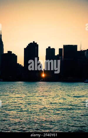 Manhattan Manhattanhenge New York City skyline seen at sunset with sunlight backlighting and seen between the buildings. Stock Photo