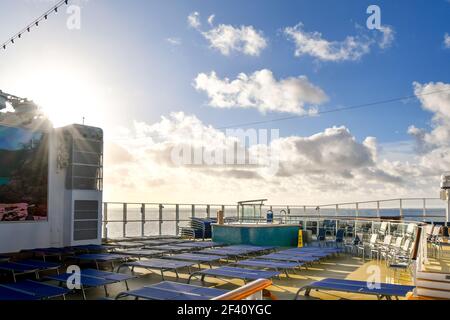 Upper deck lounge area with chairs, lounges and a hut tub on a cruise ship liner at sea. Stock Photo