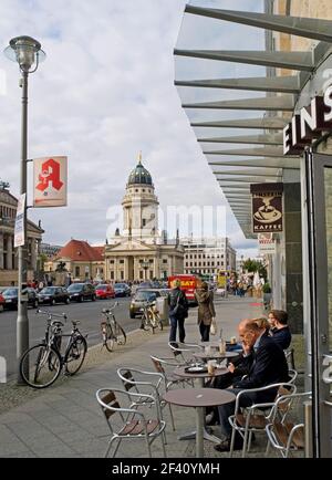 outdoor cafe at corner of Gendarmenmarkt with French Cathedral in the background in Berlin, Germany Stock Photo