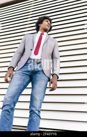 Black confident Businessman wearing suit walking in urban background. Man with afro hair.. Black Businessman wearing suit walking in urban background. Stock Photo