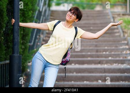 Funny happy middle-aged woman wearing eyeglasses in an urban park.. Funny happy middle-aged woman in an urban park. Stock Photo
