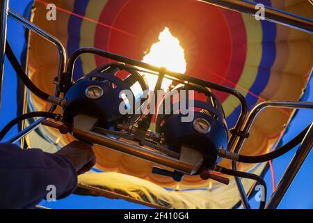 Pilot lighting the burners to heat the air inside the balloon for takeoff. Captive balloons in Aeroestacion Festival in Guadix Stock Photo