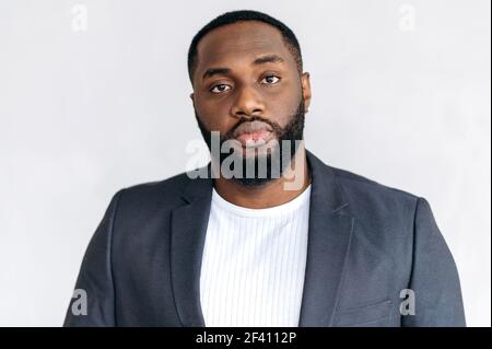 Headshot portrait of influential stylish african american male boss. Confident young adult businessman in formal suit looking directly at the camera, leadership concept Stock Photo