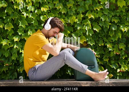 Male student sitting outside worried about his exams. Young student sitting outside worried about his exams Stock Photo