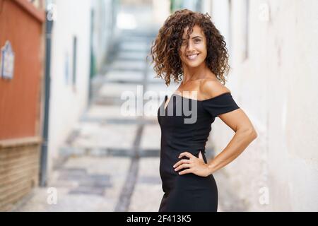 Beautiful brunette middle-aged woman in her 40s wearing dress outdoors.. Beautiful brunette middle-aged woman wearing dress outdoors Stock Photo