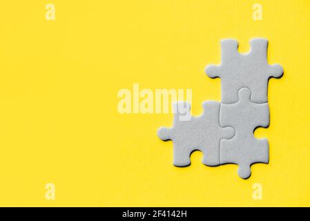Demonstrating trendy Color of the Year 2021. Illuminating Yellow and Ultimate Gray. Duotone. Multiple grey puzzle pieces put together without one Stock Photo