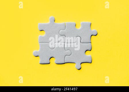 Demonstrating trendy Color of the Year 2021. Illuminating Yellow and Ultimate Gray. Duotone. Multiple grey puzzle pieces put together without one Stock Photo