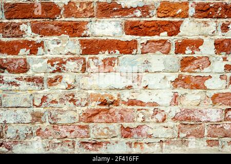 Old brick wall. Grunge background. Empty Old Brick Wall Texture. Painted Distressed Wall Surface. Grunge Red Stonewall Background. Shabby Building Facade With Damaged Plaster.. Old brick wall. Grunge background. Shabby Building Facade With Damaged Plaster. Stock Photo