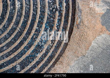 Old Rusty Manhole Cover Circular Pattern With Sand Or Dirt On The Edge, Room For Text. Old Rusty Manhole Cover Circular Pattern With Sand Or Dirt On The Edge Stock Photo