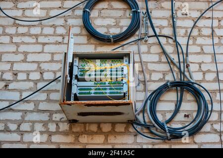 Fiber Optic Patch Panel On Apartment Building Wall With Coils Of Wires Near. Fiber Optic Patch Panel On Apartment Building Wall Stock Photo