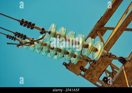 Glass electrical insulators on power-tower from below view. Glass electrical insulators from below Stock Photo