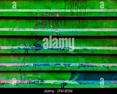 A worn and tarnished metal profiled green sheet is used as a fence Stock Photo