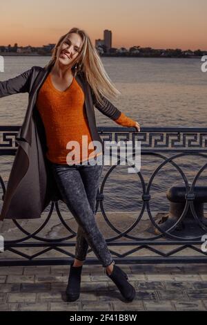 Happy blonde girl with crossed legs in tight jeans. Happy blonde girl with crossed legs Stock Photo