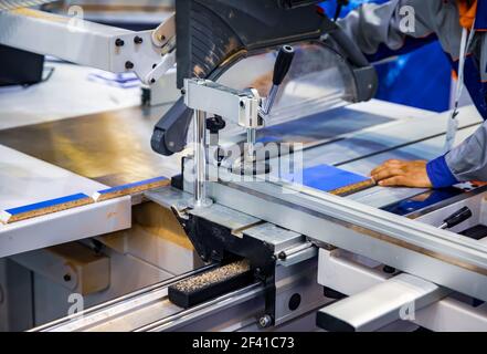 Carpenter worker operating wood cutting machine. CNC woodworking wood processing machine, modern technology in the industry. Stock Photo