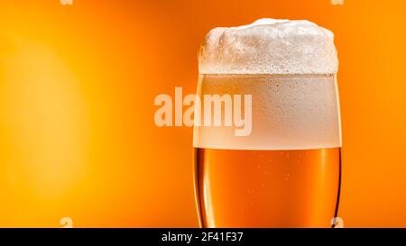 Lager beer settles in the glass with a white cap of foam Stock Photo