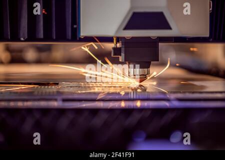 CNC Laser cutting of metal modern industrial technology. Laser cutting works by directing the output of a high-power laser through optics. Laser optics and CNC computer numerical control. Stock Photo