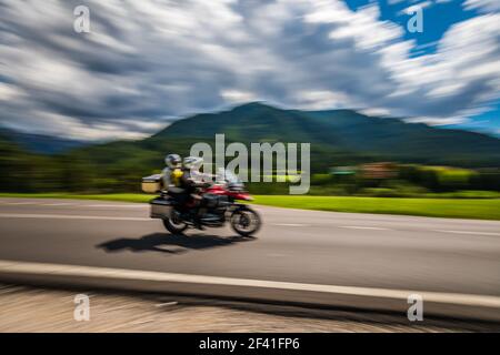 Blurred motion Couple Bikers riding a tricycle on the road. Stock Photo