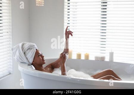 African american woman bathing in bathtub at bathroom Stock Photo