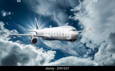 Passenger Airliner flying in the clouds Stock Photo