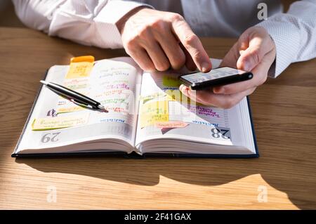 Writing Agenda Week Plan List Using Mobile Phone Stock Photo