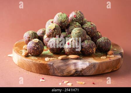 Raw energy balls with matcha tea powder on wooden board on beige background. Raw vegan, vegetarian sweets. Sugar free, gluten free, lactose free Stock Photo