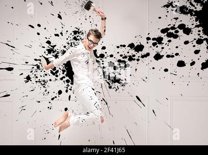 Conceptual portrait of a young jumping painter Stock Photo