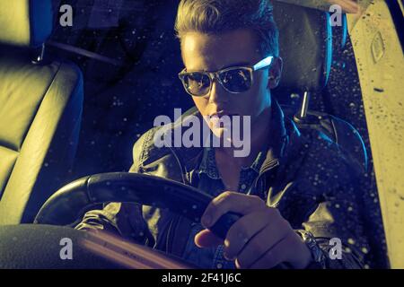 Handsome young man holding a steering wheel Stock Photo