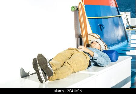 Young hipster man having rest on ferry boat passage holding smartphone  - Modern concept of inspired freedom and wander lifestyle Stock Photo