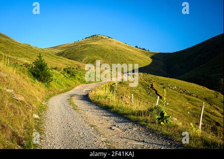 Stone path ascending up a grassy hill on a beautiful sunny day Stock Photo