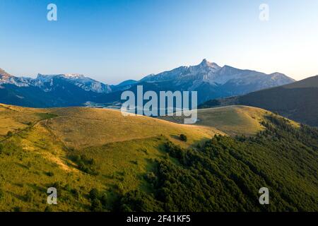 Stunning grassy hill in front of the mountain landscape Stock Photo