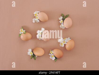 2021 Easter composition. Eggs with white flowers and leaves. Flat lay minimal background. Stock Photo