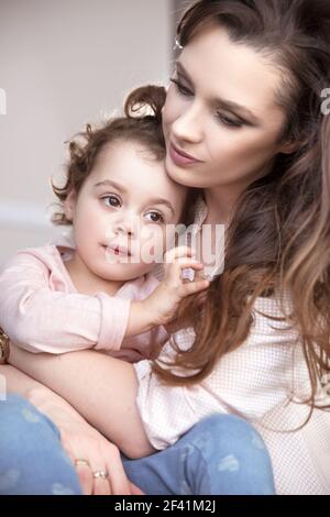 Pretty mom hugging her beloved daughter Stock Photo