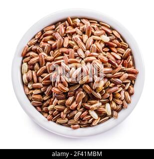 Brown rice - whole grain rice with outer hull or husk in ceramic bowl on white background. File contains clipping path. Stock Photo
