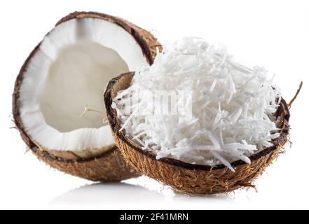 Coconut fruit and shredded coconut flakes in the piece of shell isolated on white background. Stock Photo